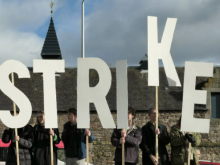 Strikers hold up letters saying "Strike"