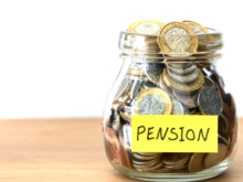 A jar full of pound coins with a yellow sticker on it, labelled "Pension"