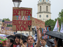 Placard reading "Better trans healthcare now!"