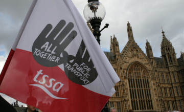 A red and white TSSA flag with the slogan "all together for public transport"
