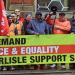Striking RMT members with a union banner reading "WE DEMAND JUSTICE & EQUALITY FOR CARLISLE SUPPORT SERVICES WORKERS"